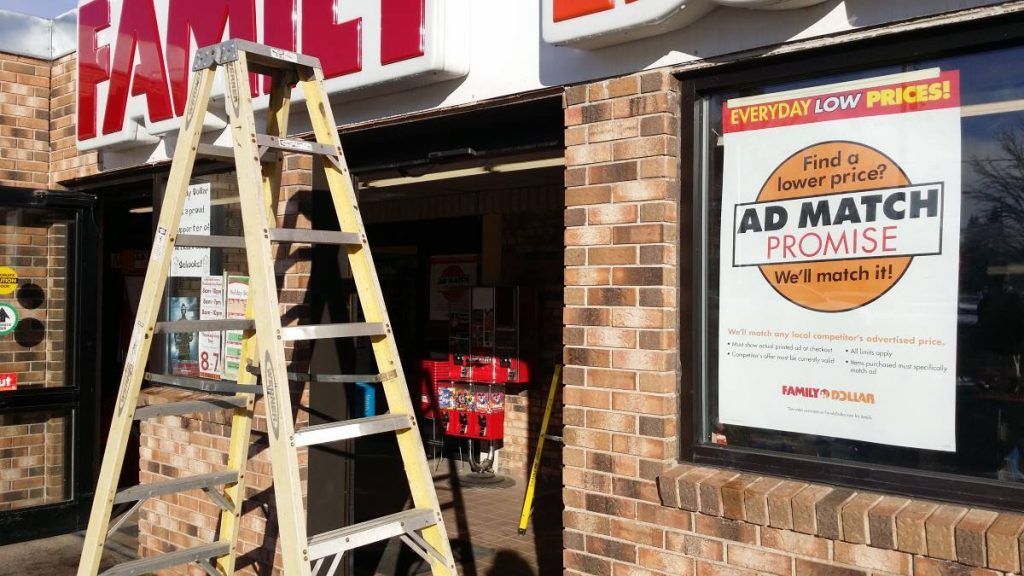 Ladder leaning against a Family Dollar store. Sign says