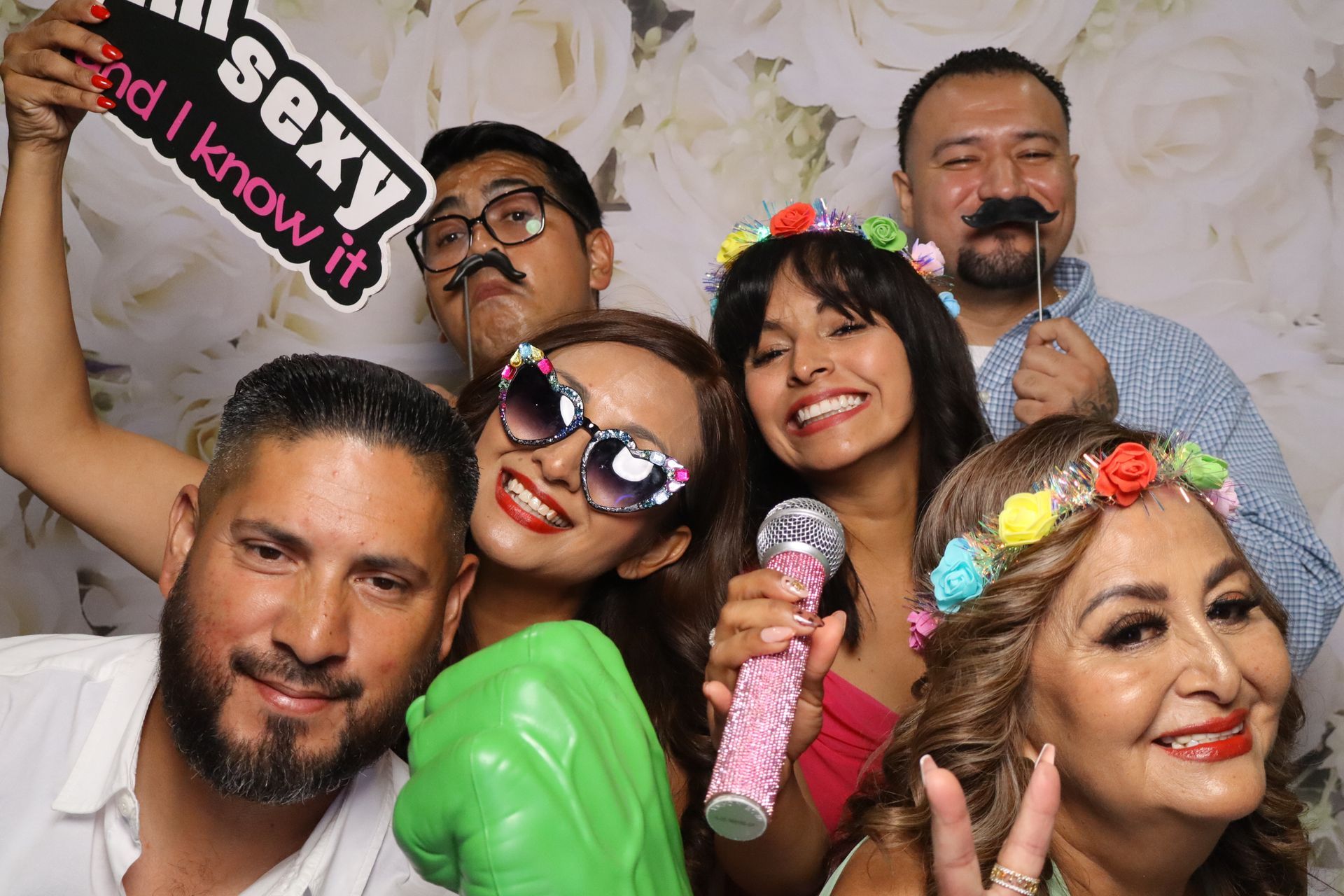 Guests smiling with fun photo booth props during a Quinceañera at London Garden