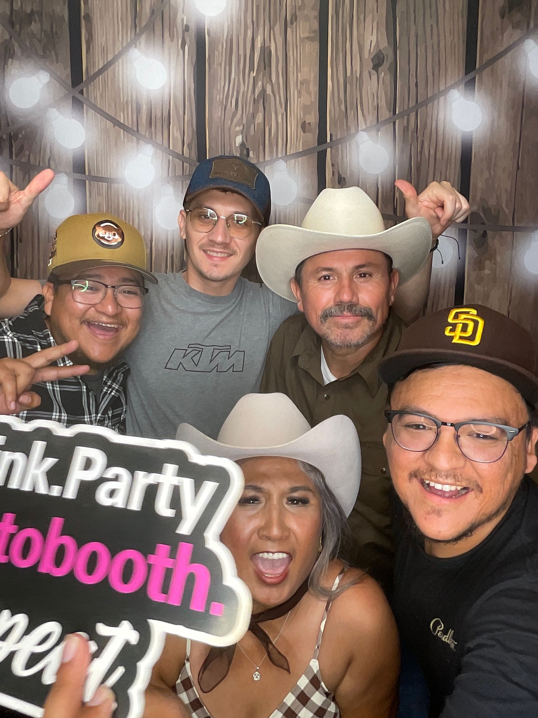 Guests enjoying Dalila’s western themed birthday photo booth with fun props at her celebration in Perris, CA