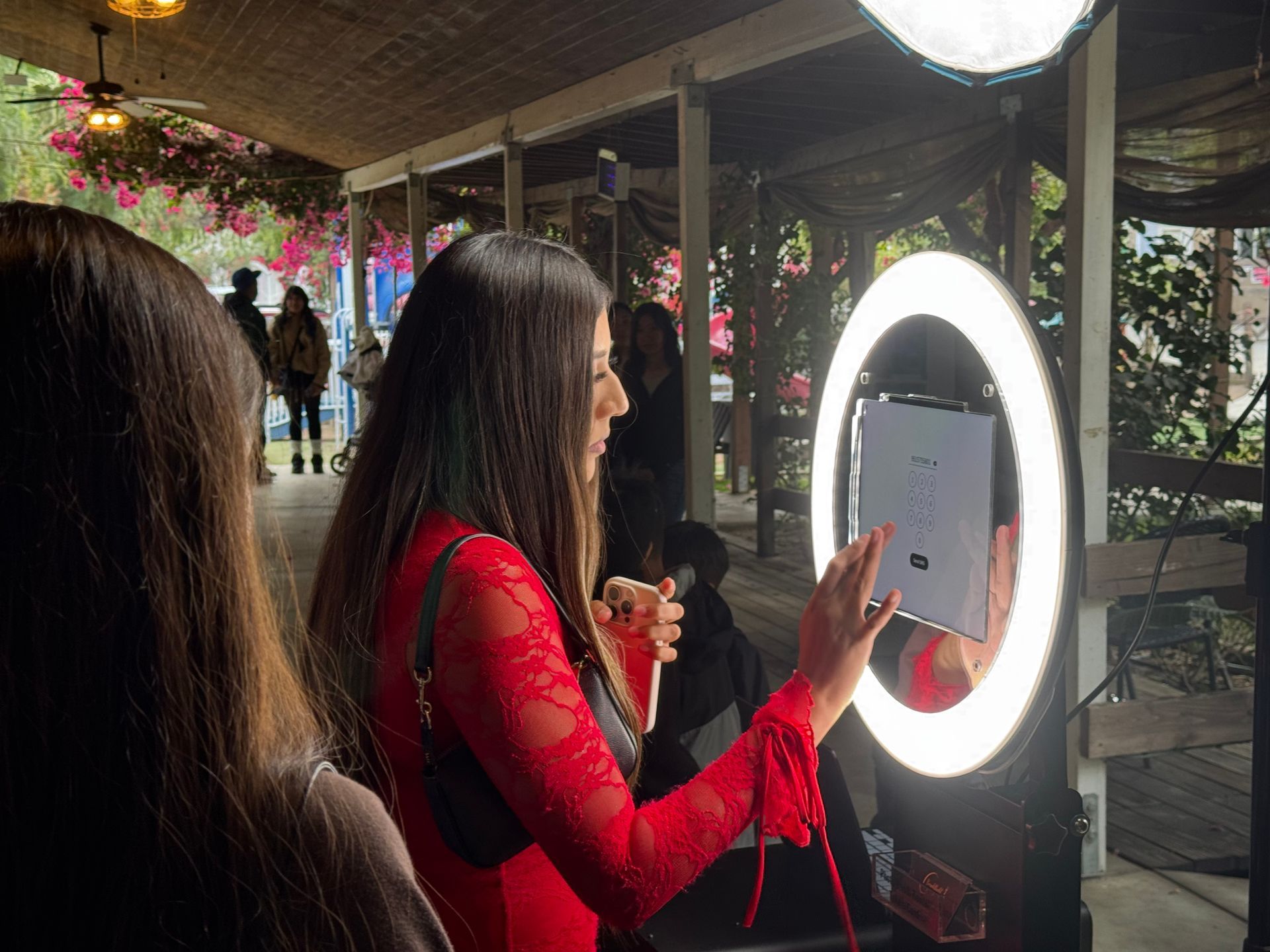 Guests using Brightlight's touchscreen digital photo booth at a quinceañera