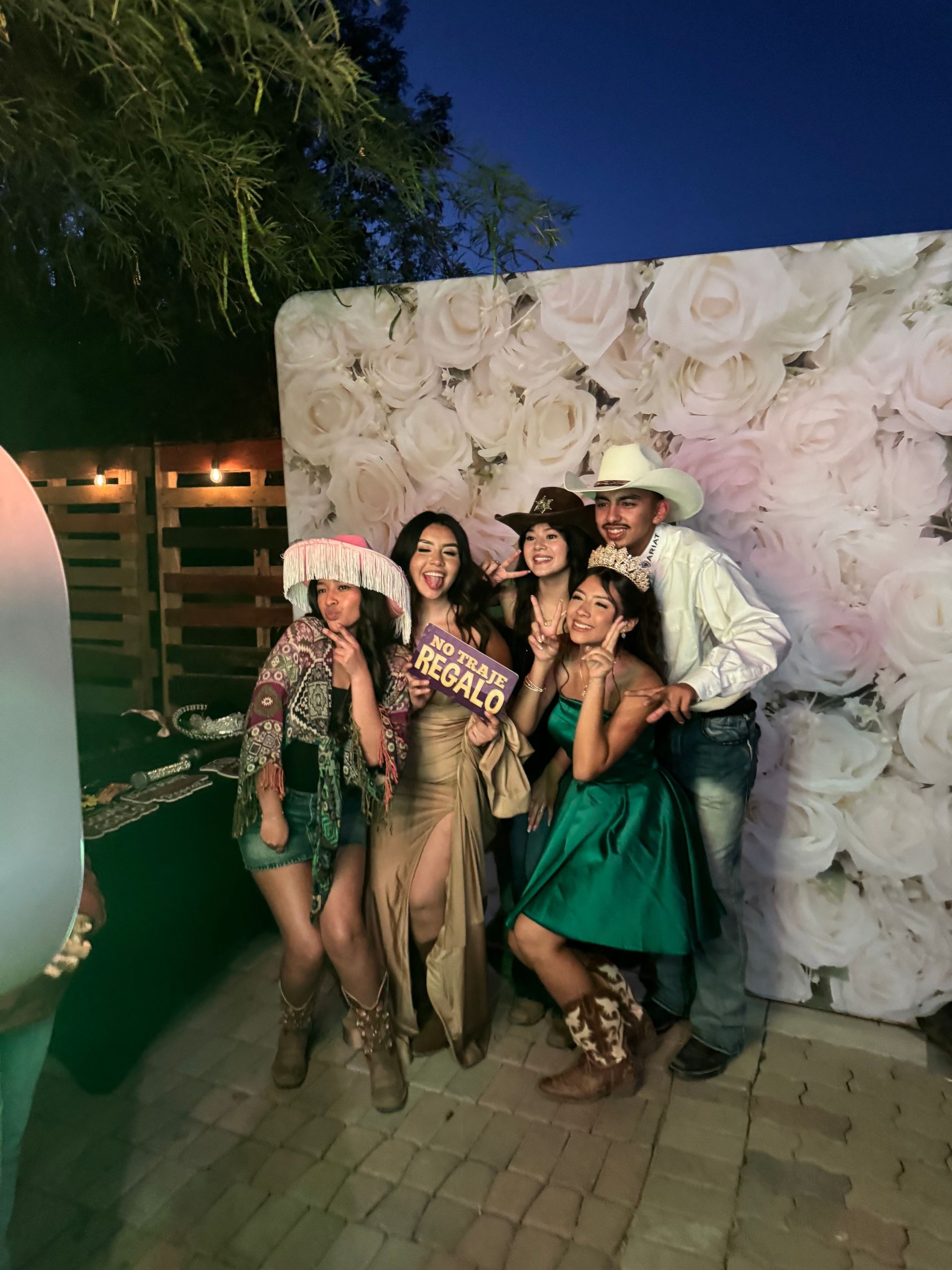 Guests having fun with photo booth props at Lily’s Quinceañera