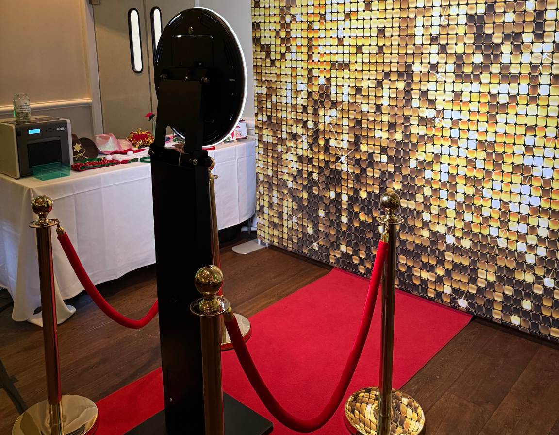 Luxury red carpet photo booth experience with gold stanchions and premium backdrop