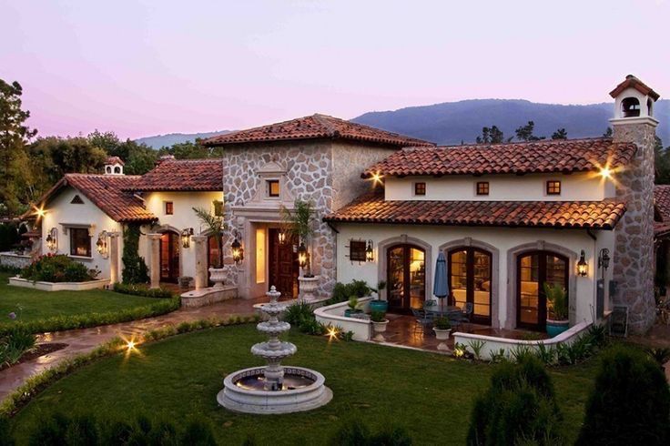 A large house with a fountain in front of it