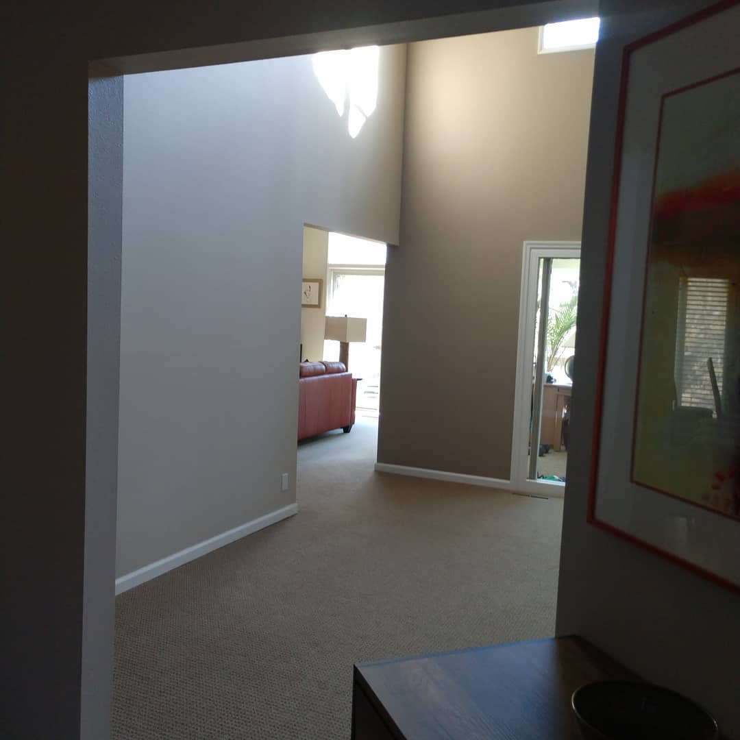 Interior view through an archway into a room with a red sofa.