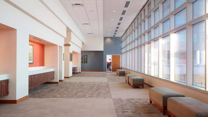 Long hallway with large windows, seating, and built-in cabinetry.