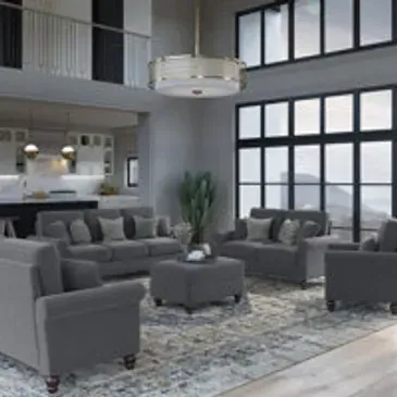Gray living room with furniture: sofas, armchairs, and ottoman on a patterned rug.
