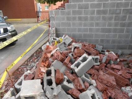 A pile of bricks and concrete blocks next to a brick wall