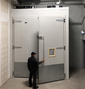 HVAC technician opening industrial fridge door