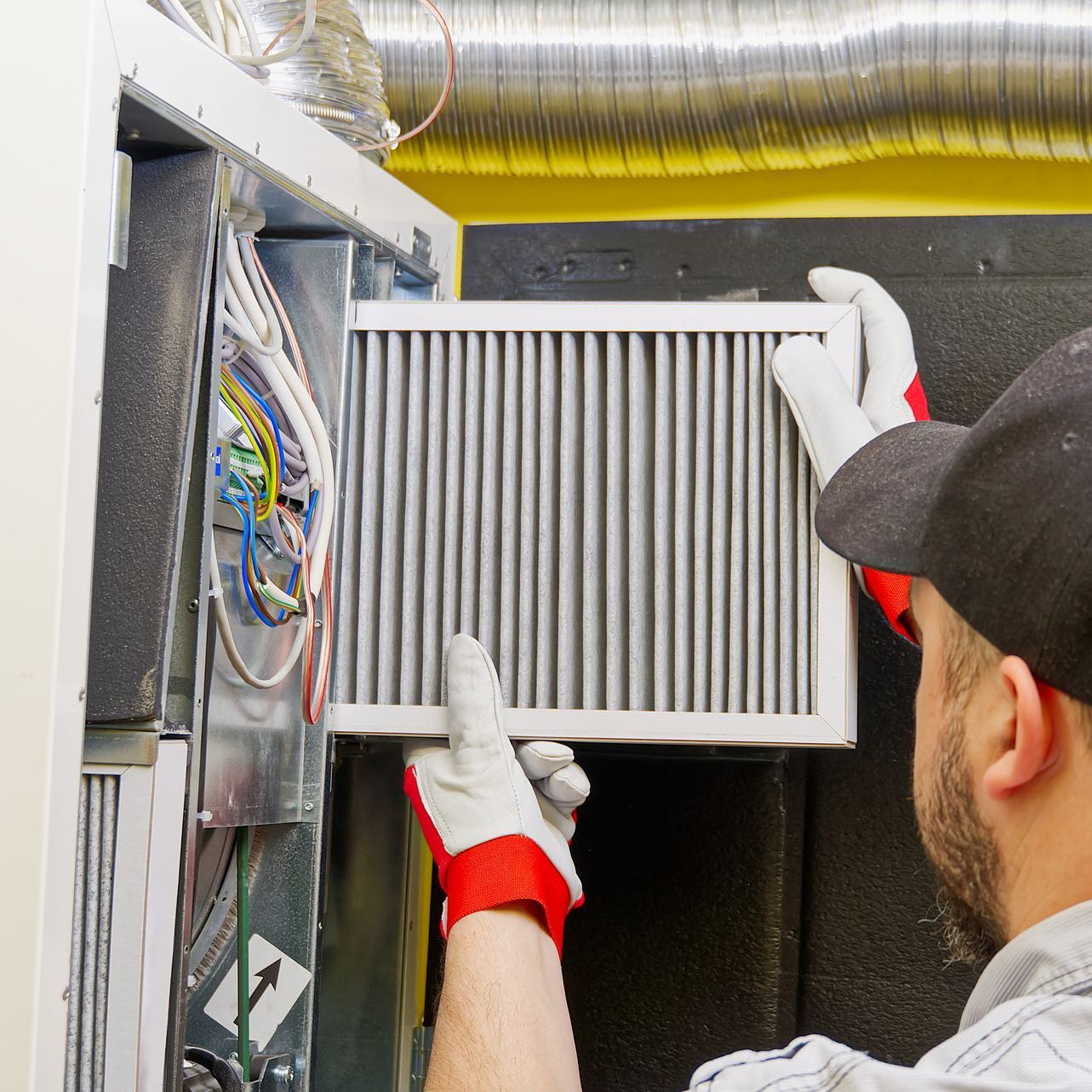 HVAC technician replacing filter during HVAC maintenance service