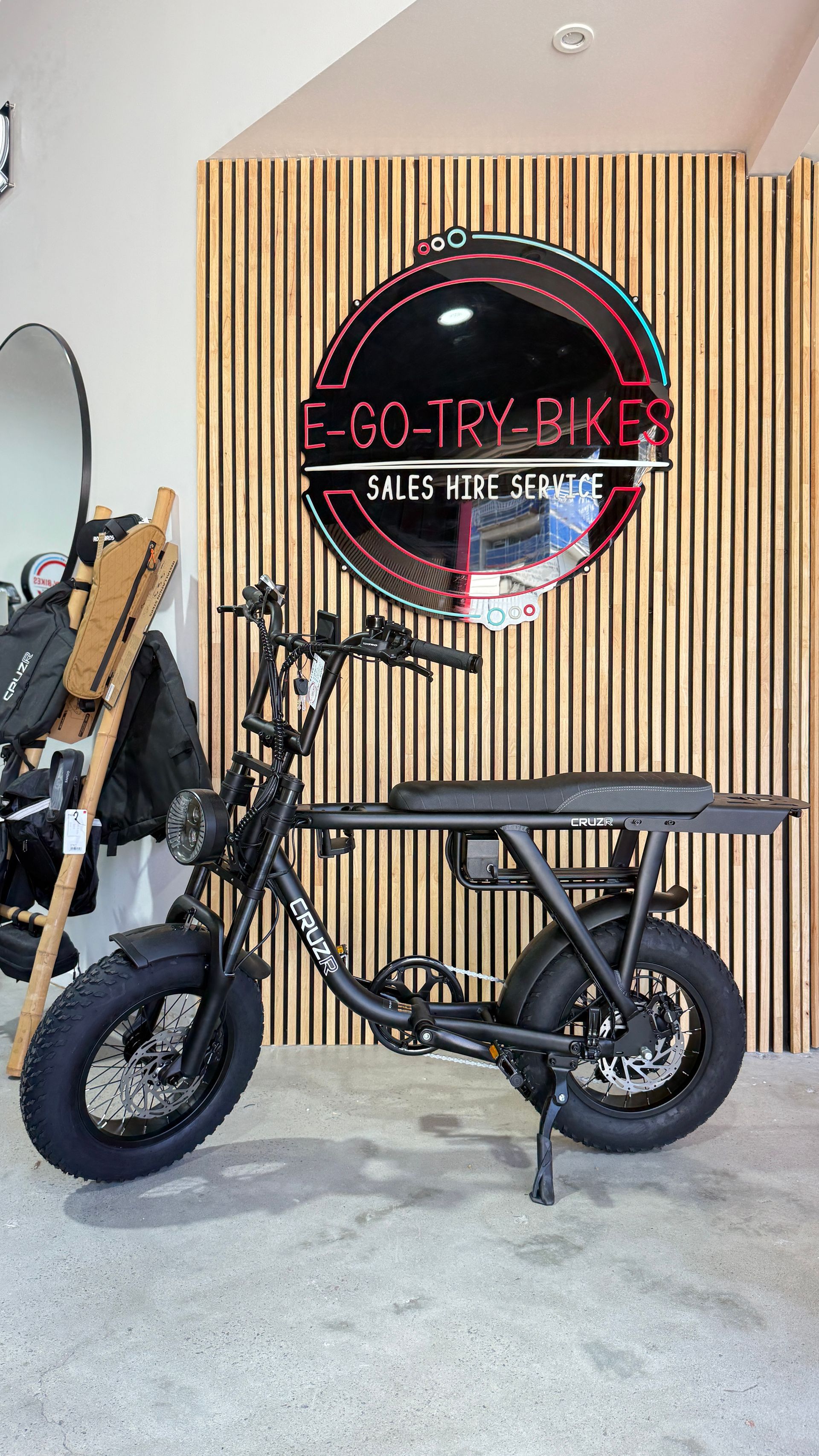 A Black Electric Moped Stands  in Front of A Wood-Slatted Wall — E-Go-Try-Bikes in Nelson Bay, NSW