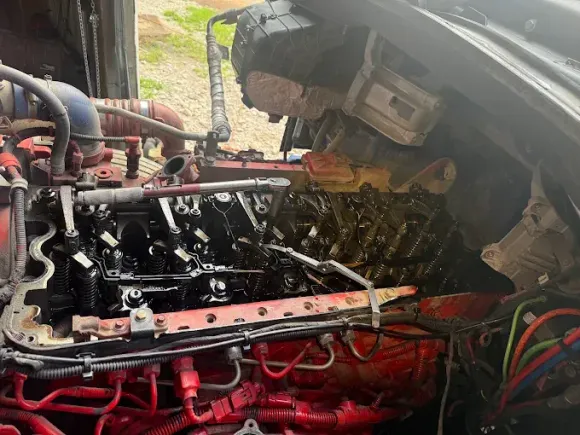 Red truck engine being worked on outdoors.