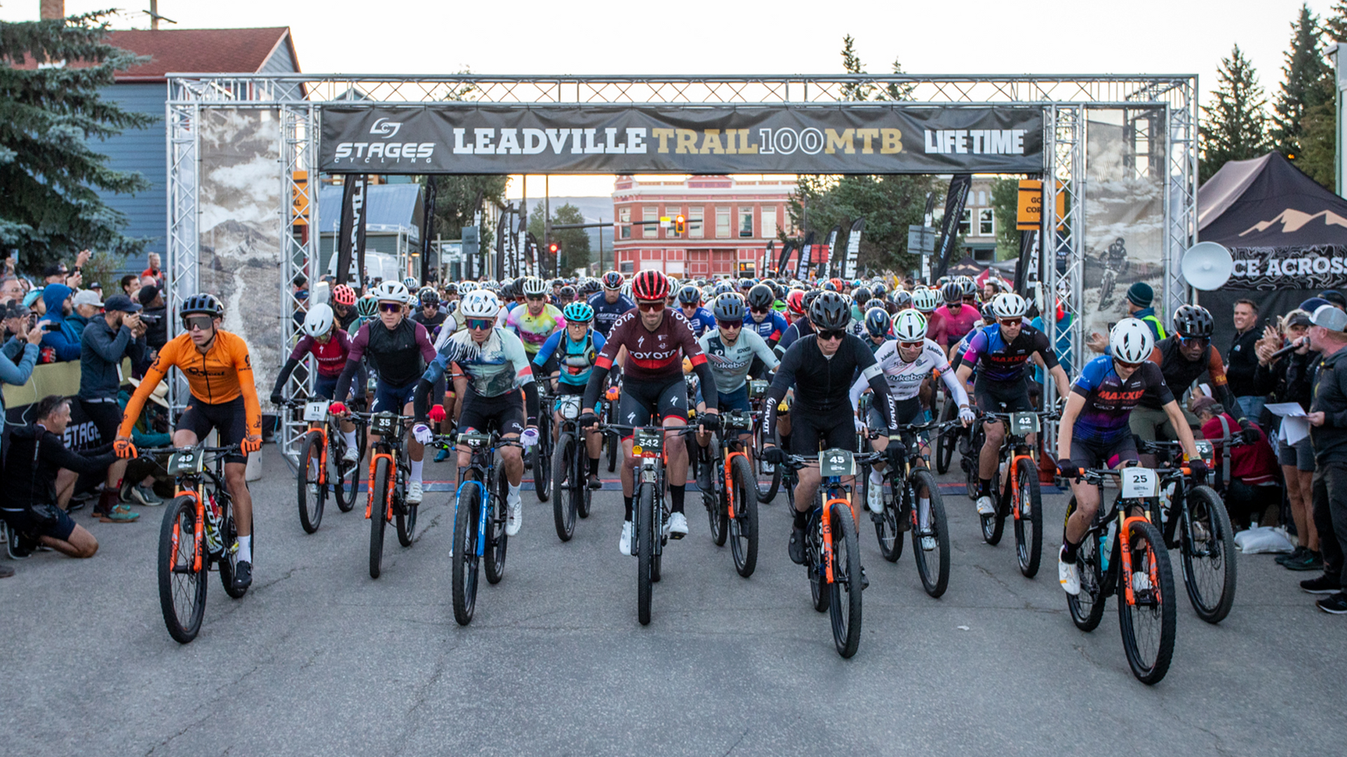A large group of people are riding bikes down a street.