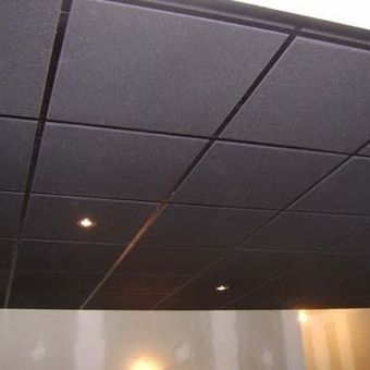 A close up of a black tiled ceiling in a room.