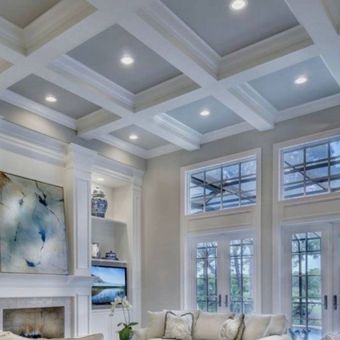 A living room with a coffered ceiling and lots of windows