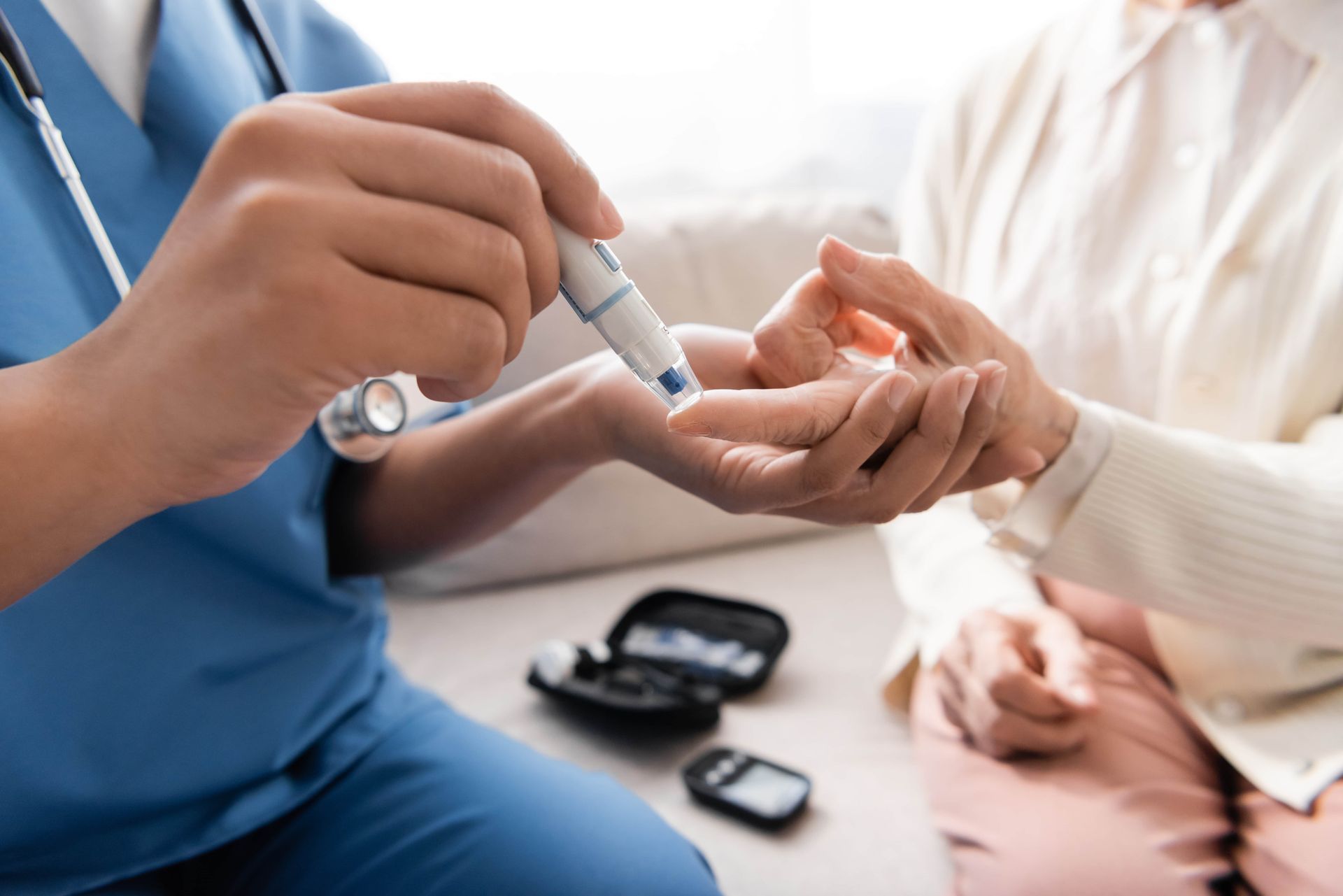 Nurse taking blood sample of senior woman with lancet pen.