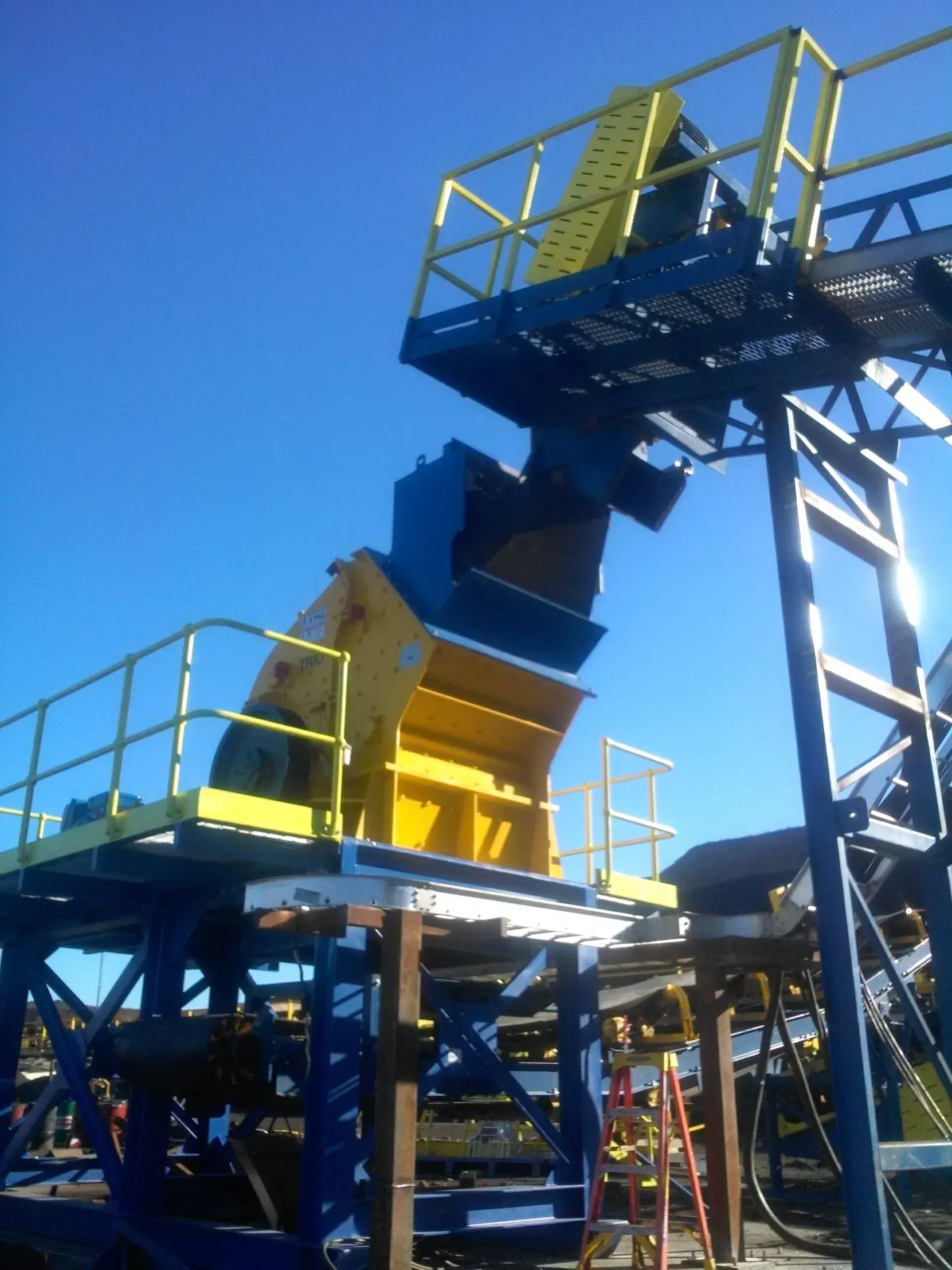 A blue and yellow machine with a yellow railing.