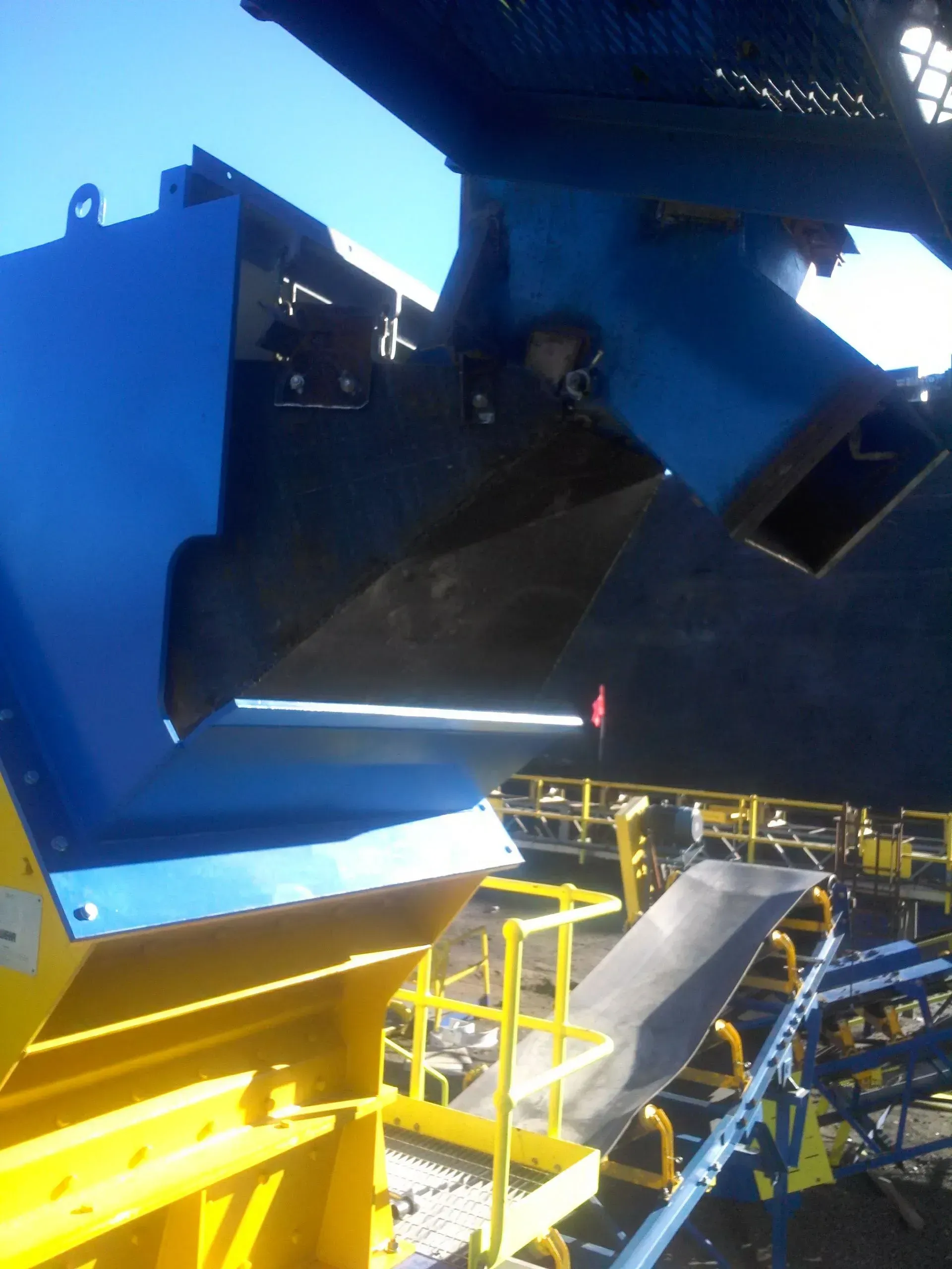 A conveyor belt with a blue box on top of it.