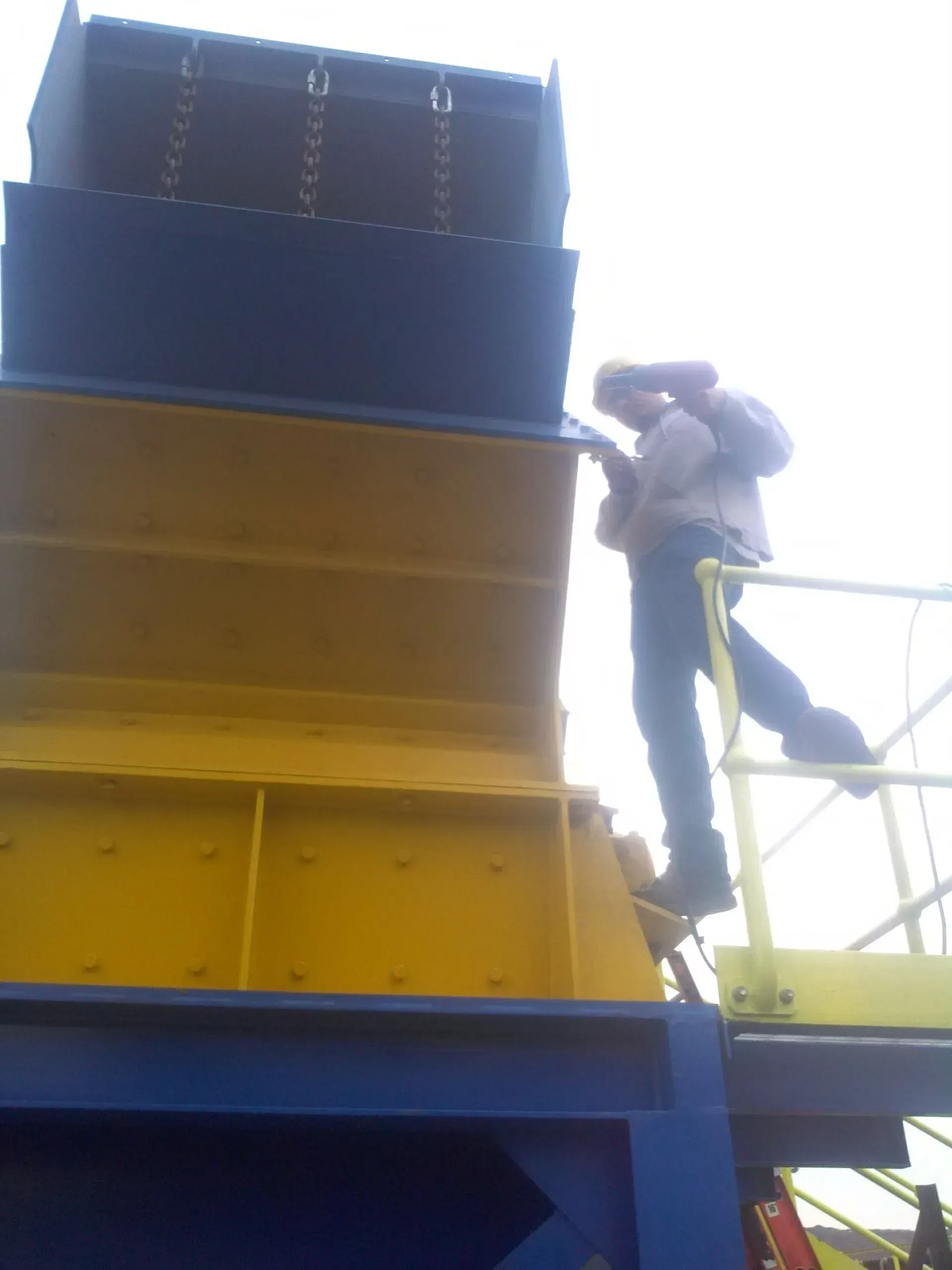 A man standing on top of a yellow and blue structure.
