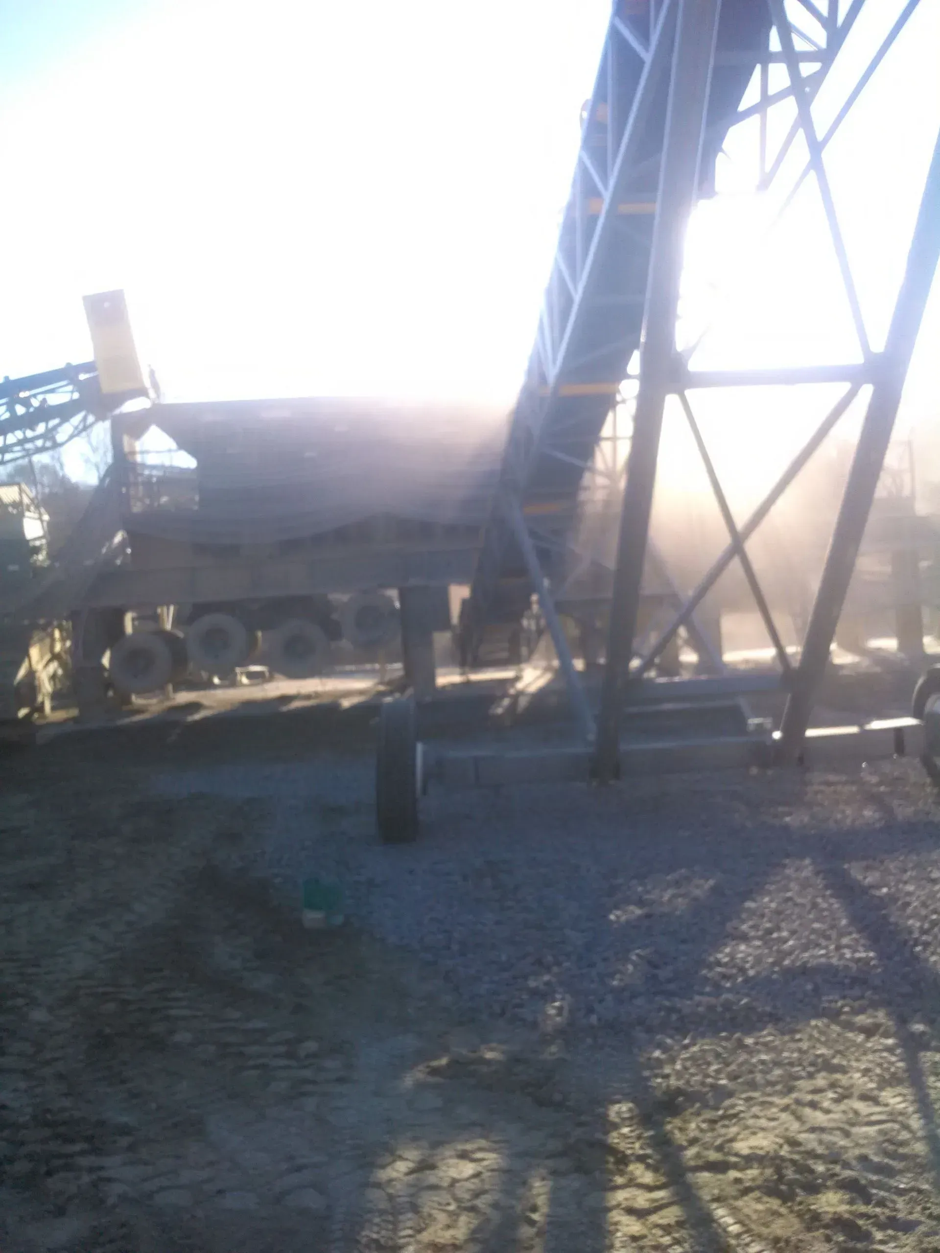 A conveyor belt with a truck in the background.