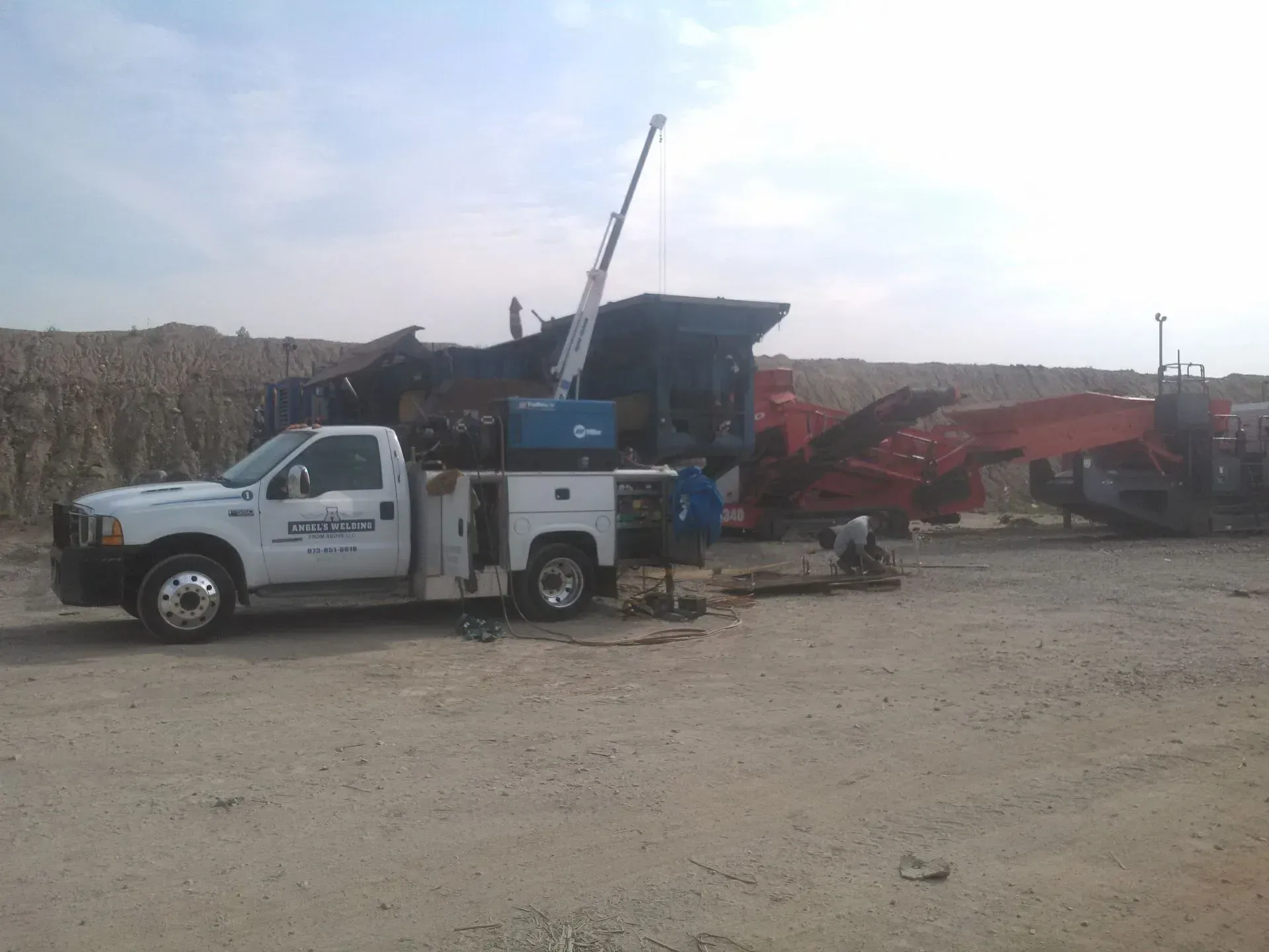 A white truck with a crane on top of it.
