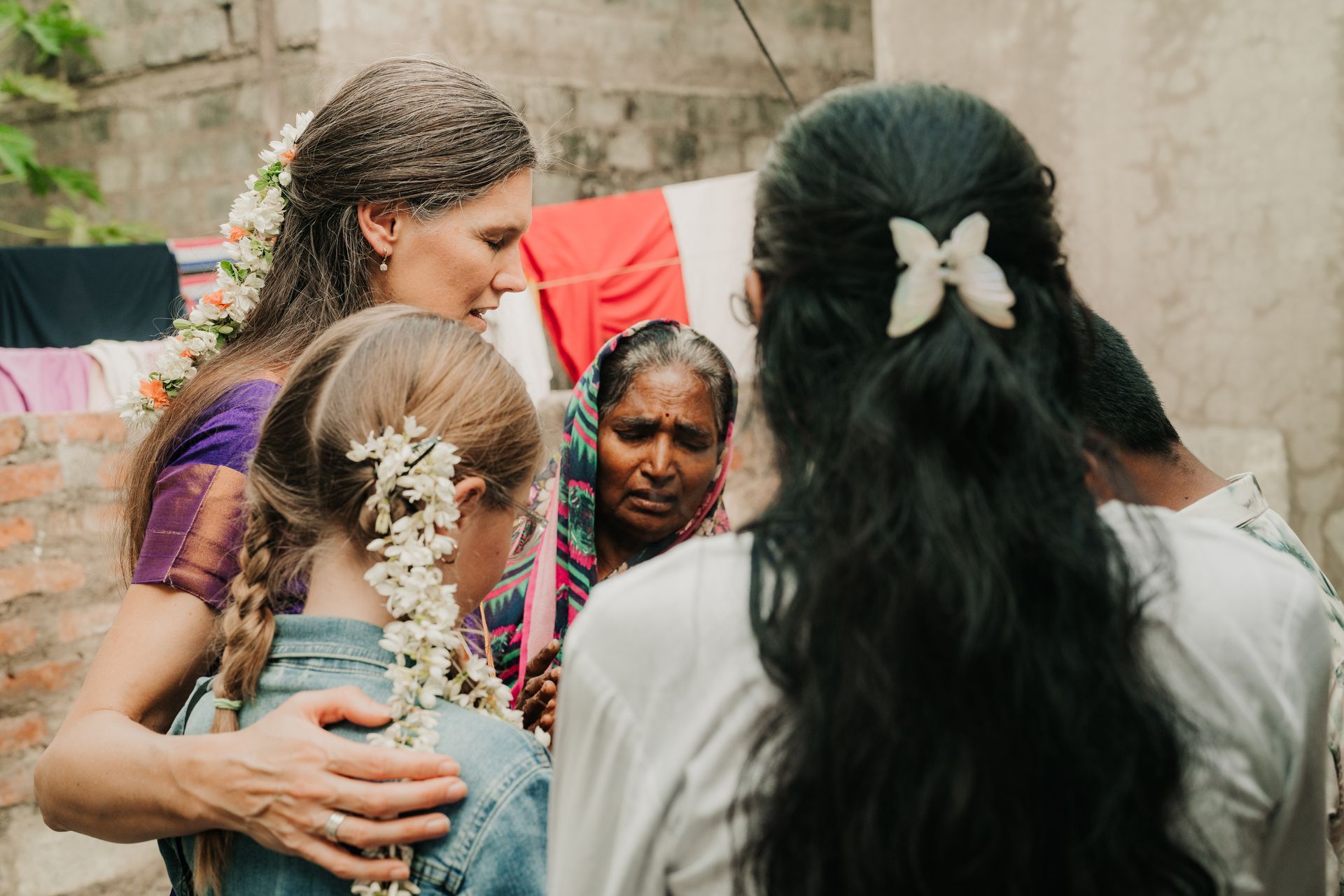 Mom and child pray for orphans and families in need in rural South Asian village