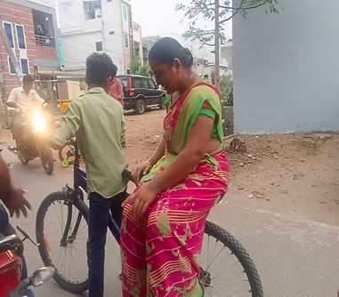 Restoring Hope student Taj gives his mother a ride on their bicycle