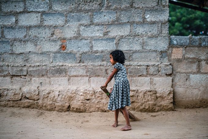 Girl sweeping outside, a common role for children of impoverished families in rural South Asia