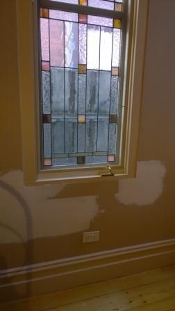There is a stained glass window in the corner of the room.