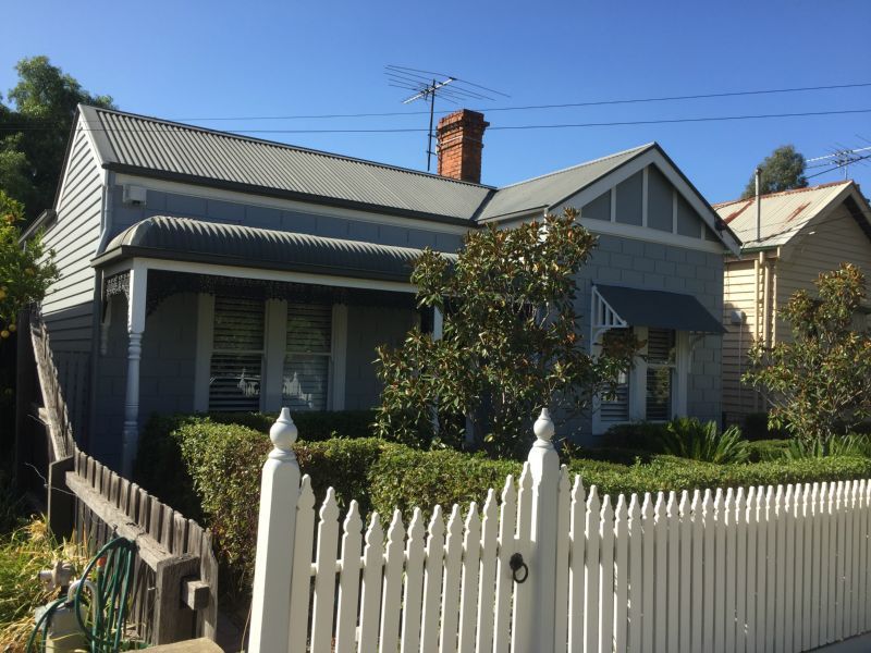 A house with a white picket fence in front of it