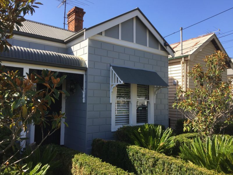 A house with a gray awning on the front of it