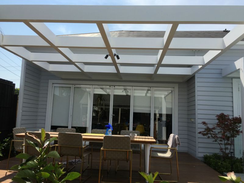 A patio with a table and chairs under a pergola