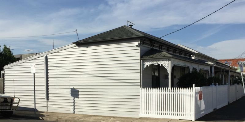 A white house with a white picket fence in front of it