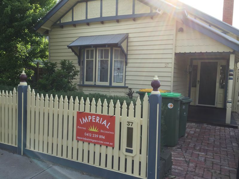A house with a fence and a sign that says imperial