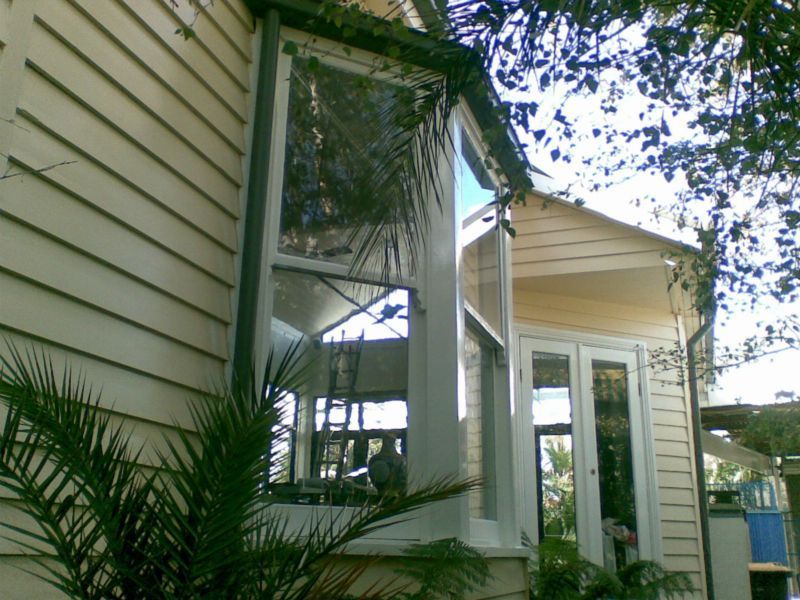 A house with a large window and a palm tree in front of it