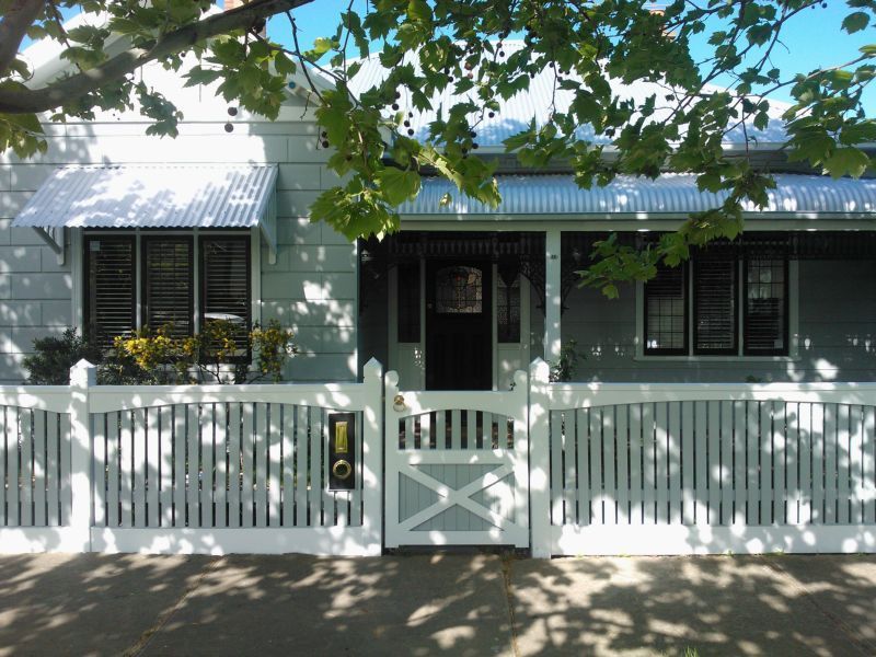 The front of a house with a white picket fence