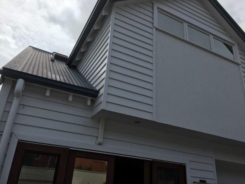 A white house with a black roof and white siding