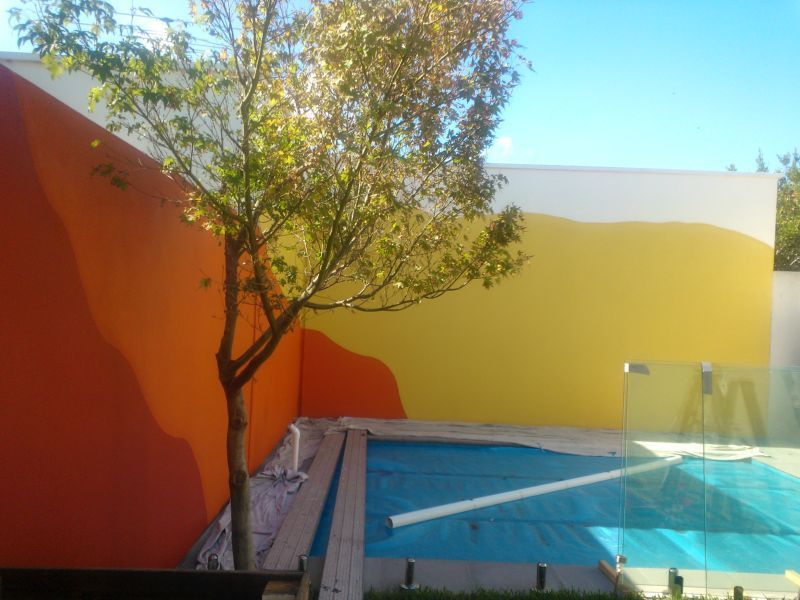 A swimming pool with a colorful wall behind it