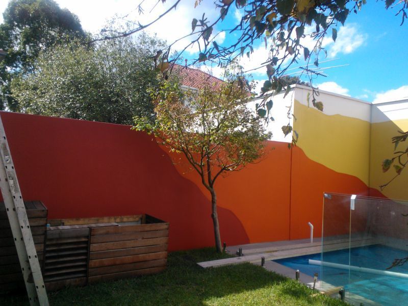 A ladder is leaning against a wall next to a pool