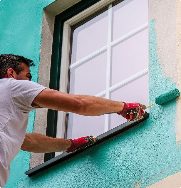 A man is painting a window with a roller
