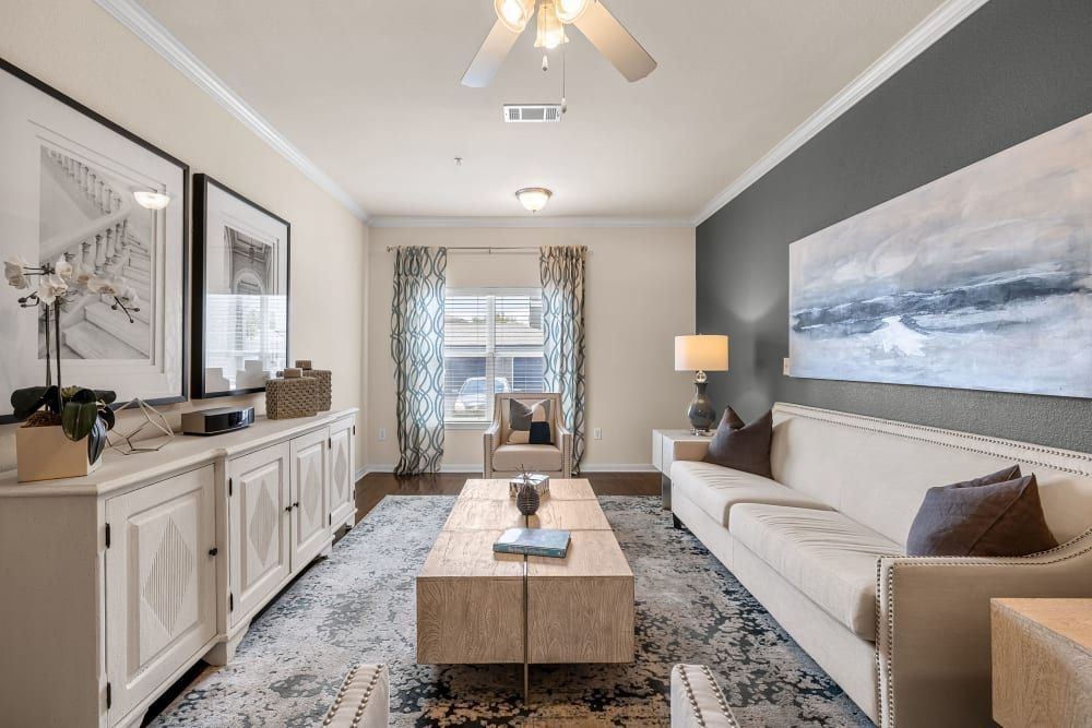 Luxury living room with a couch, coffee table, chairs, and a ceiling fan at Marquis at The RIM in Northwest San Antonio, TX.