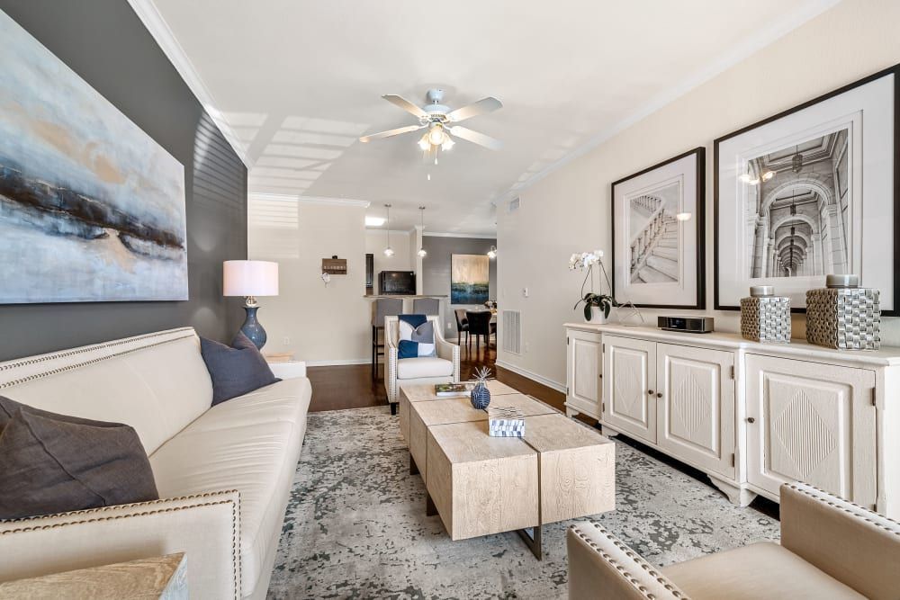 A living room with a couch, chairs, coffee table, and a ceiling fan at Marquis at The RIM in Northwest San Antonio, TX.