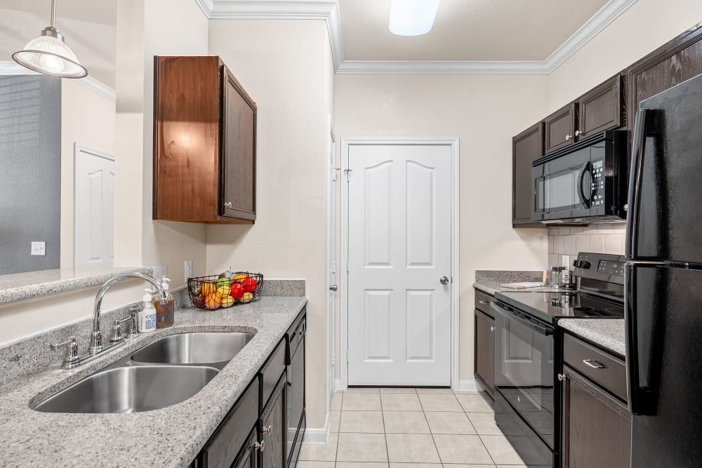 Modern kitchen with stainless steel appliances and granite counter tops at Marquis at The RIM in Northwest San Antonio, TX.