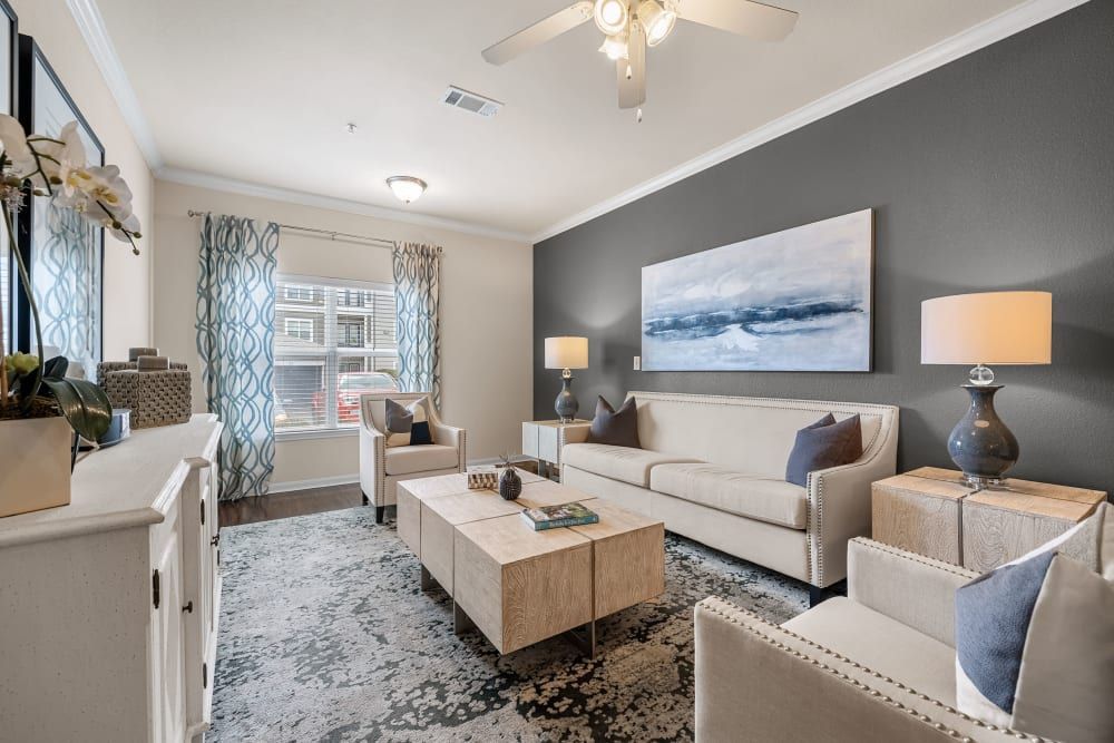 Modern living room with a couch, chairs, coffee table, and a ceiling fan at Marquis at The RIM in Northwest San Antonio, TX.
