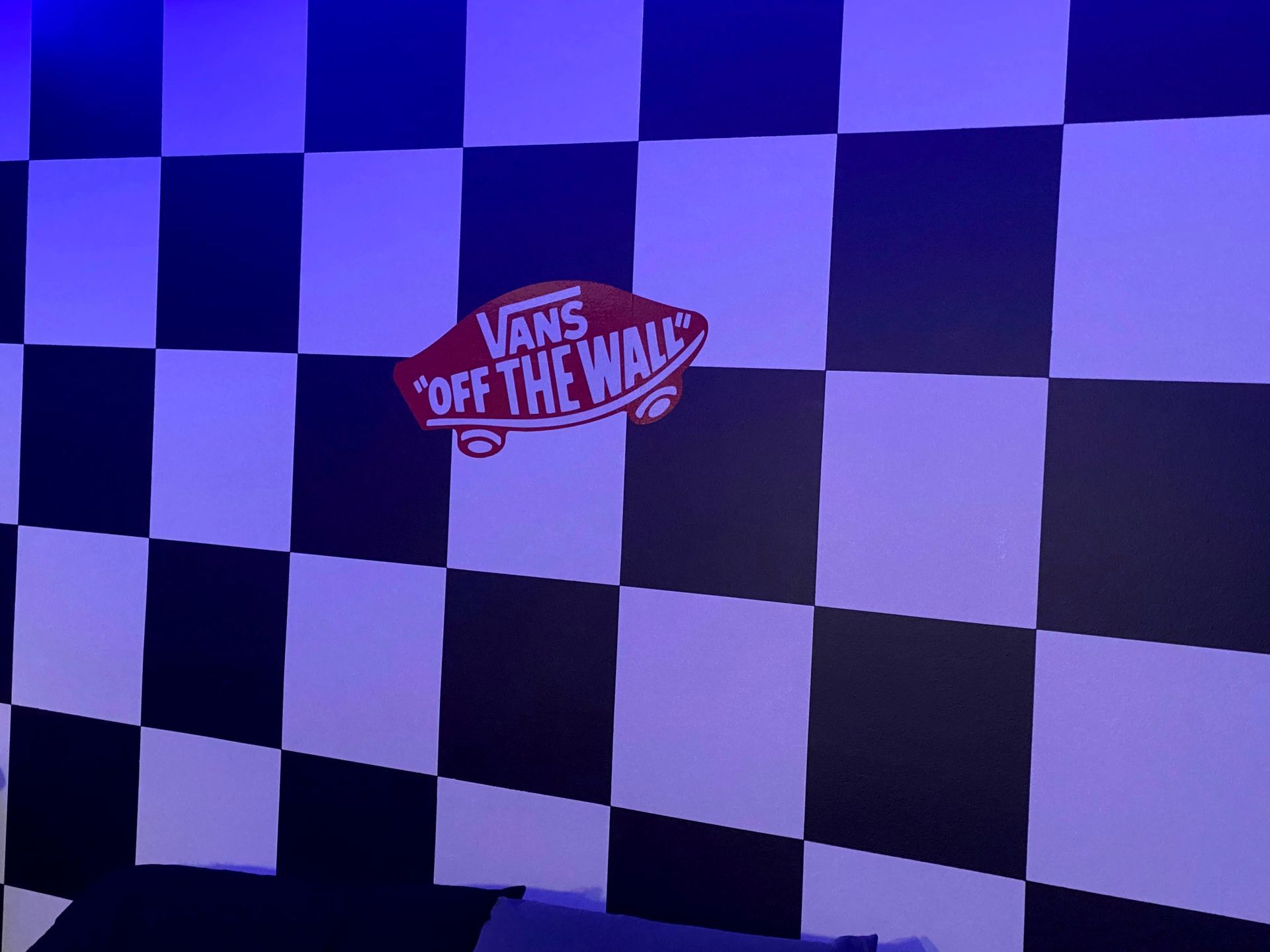 Black-and-white checkered flag with a Vans Off The Wall logo in the center
