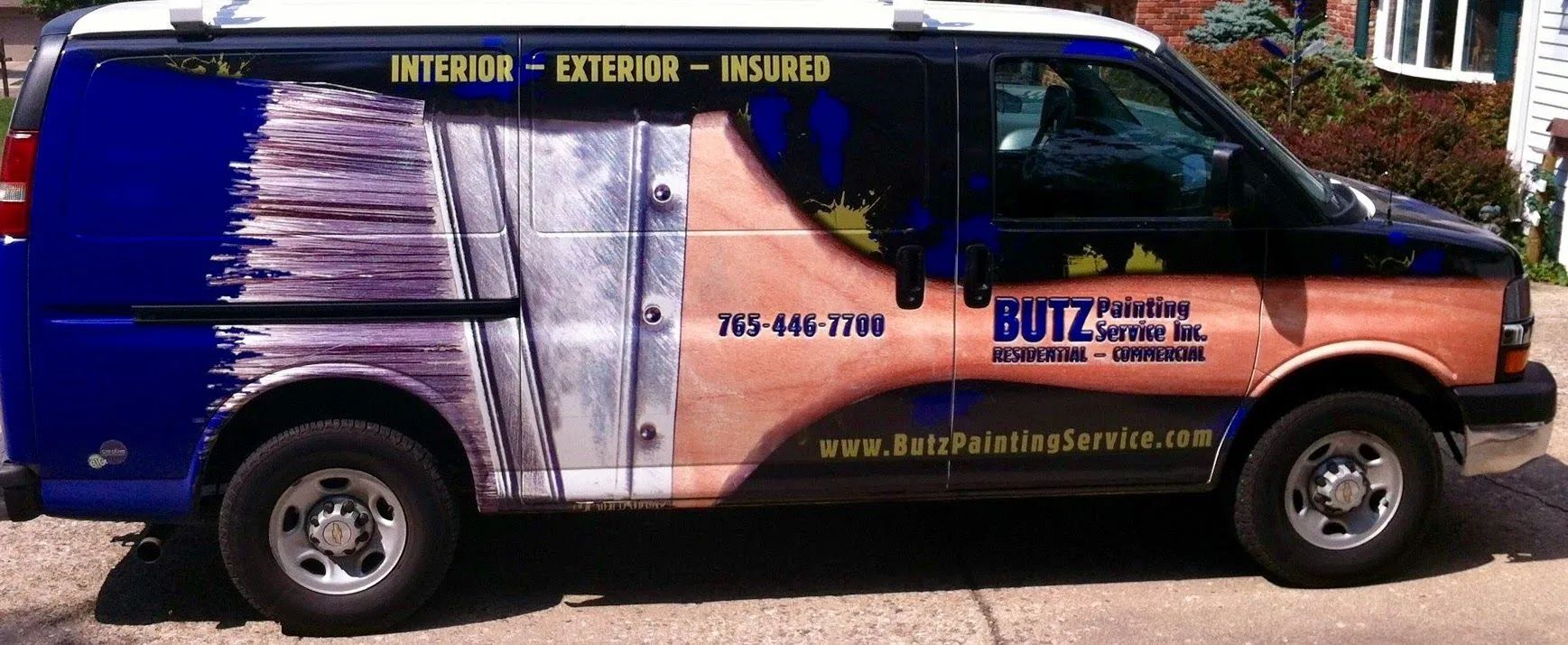 Blue-and-orange van with business signage parked on a street