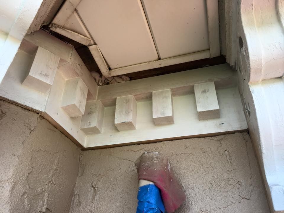 Damaged ceiling corner with exposed wood beams and a blue/red object below