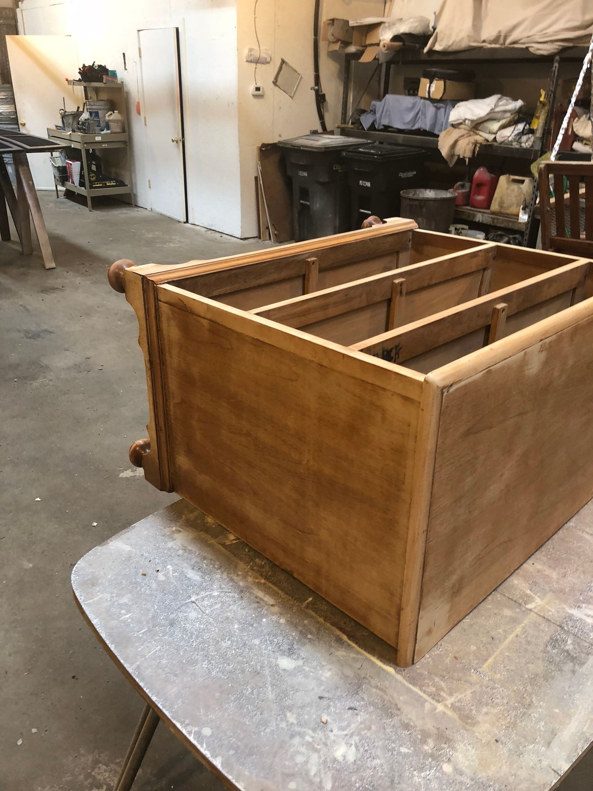 Wooden crate or shelf box in a workshop, resting on a padded workbench.