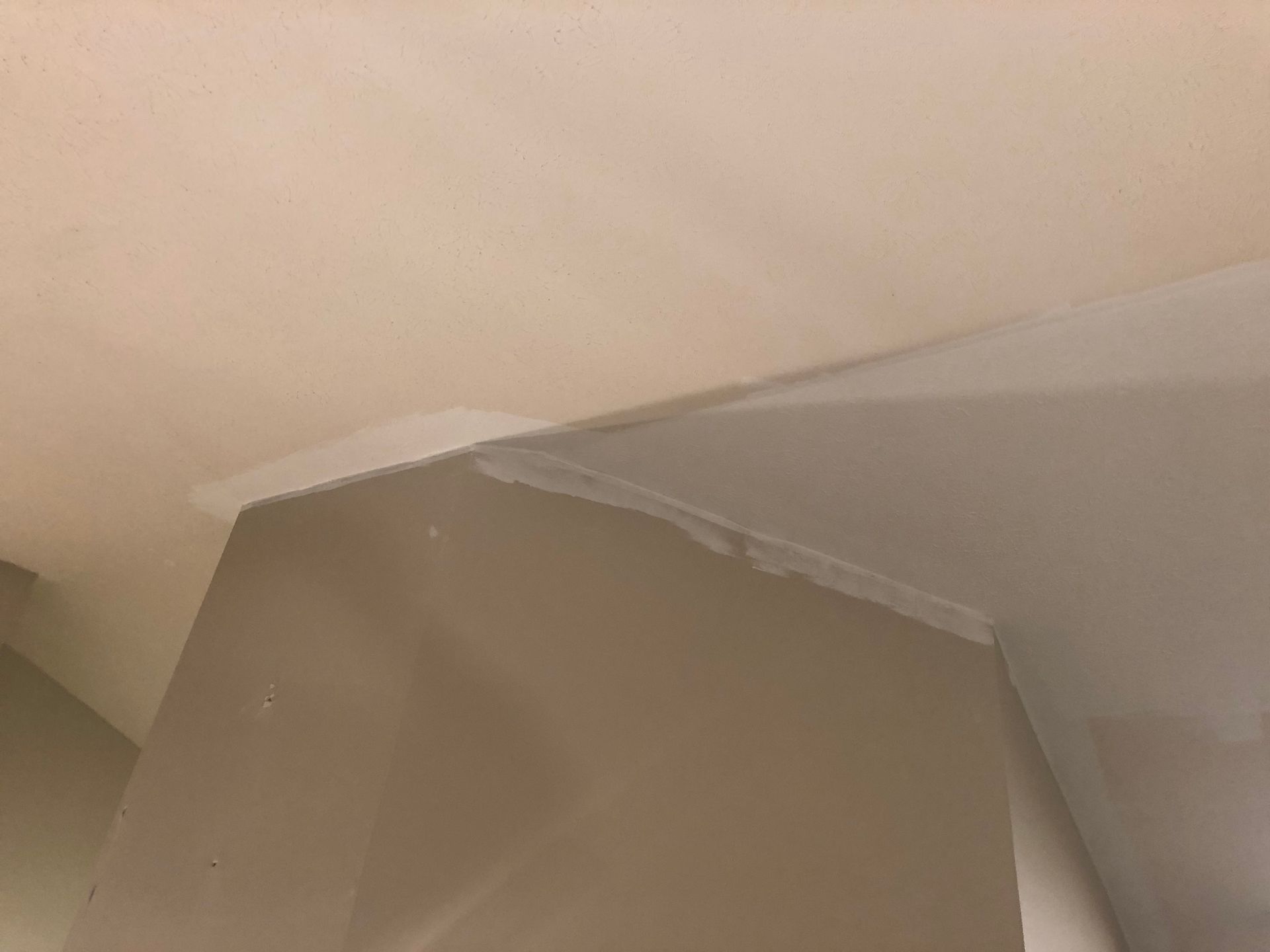 Brown cardboard box under a beige ceiling corner with white trim