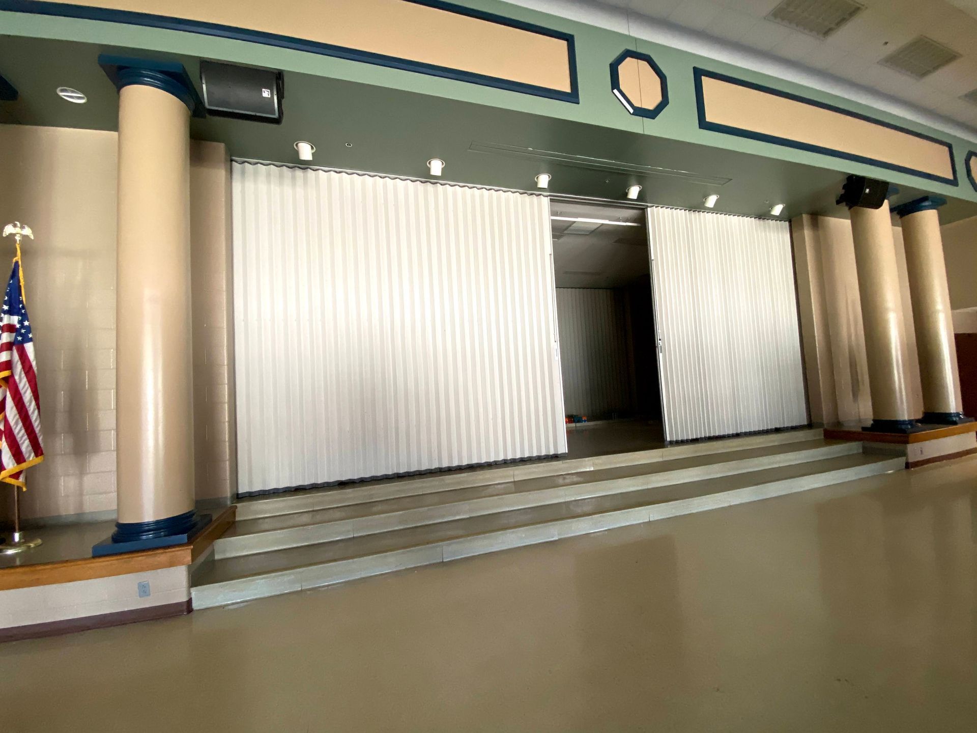 Empty stage with beige columns and white curtains in a spacious hall