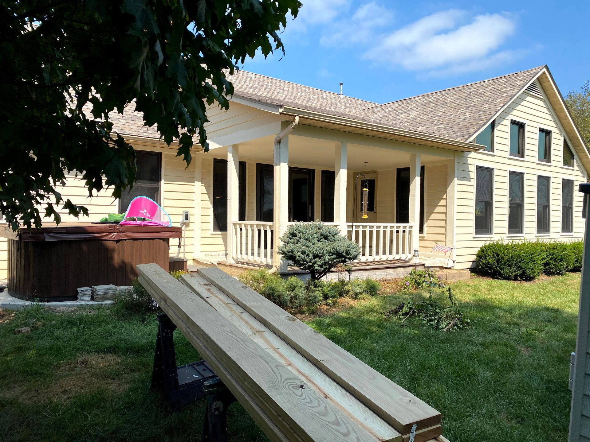 Suburban house with a porch, backyard deck, and a wooden ramp leading up to the entrance.